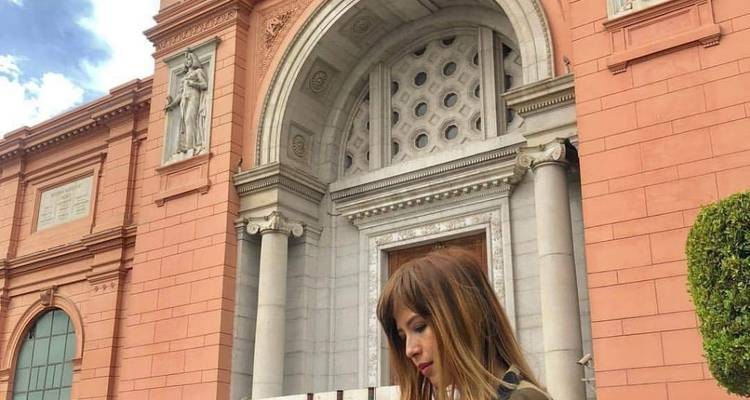 Eine Frau, die vor einem historischen Gebäude steht.