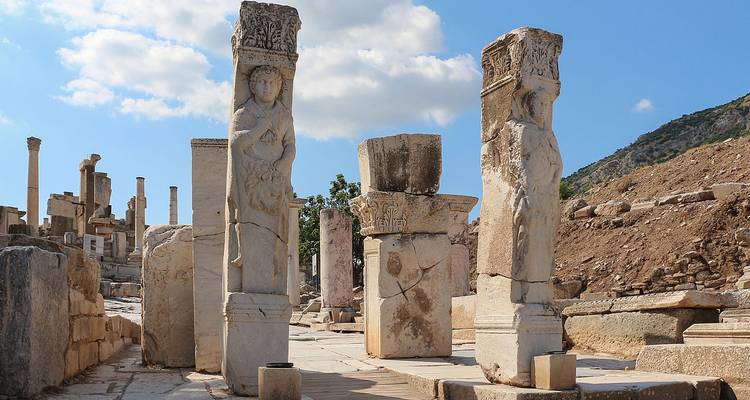 Ruines anciennes avec des colonnes et des sculptures décoratives.