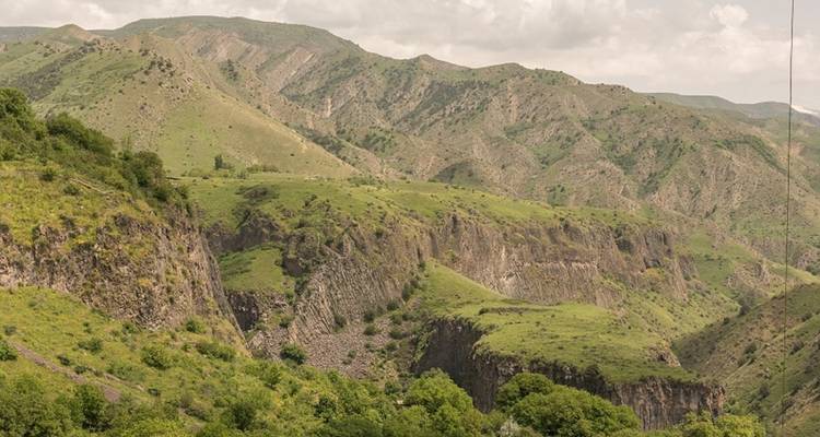 Canyonlandschap met groene begroeiing en ruw terrein.