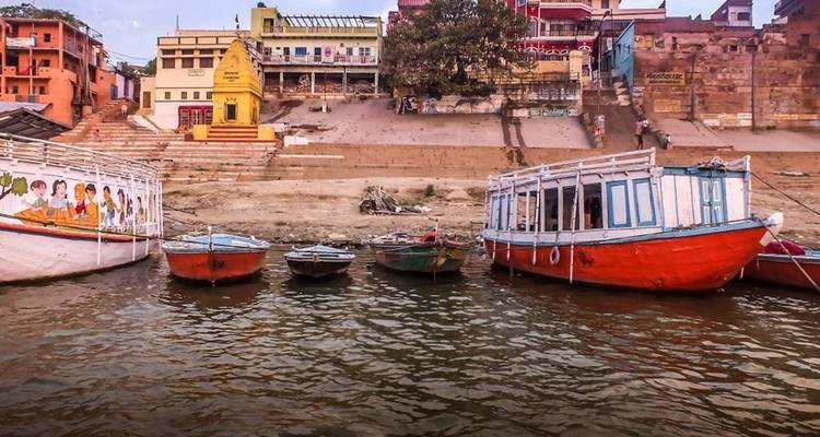 Boats along the riverbank with colorful buildings.