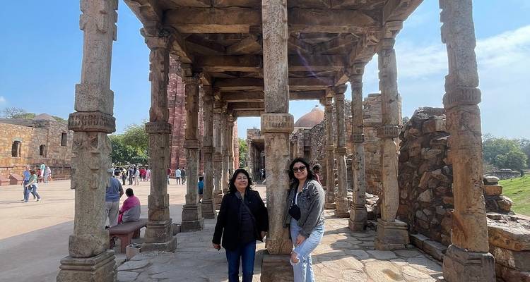Deux femmes debout dans un site historique avec des colonnes de pierre.