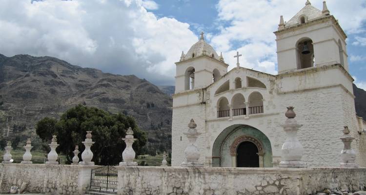 Église blanche avec des montagnes en arrière-plan.