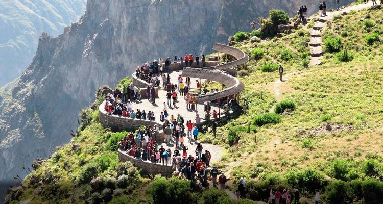 Des touristes se sont rassemblés sur un sentier sinueux avec vue sur les montagnes.