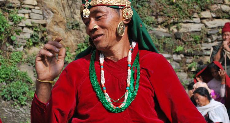 Homme vêtu de manière traditionnelle participant à un événement local.