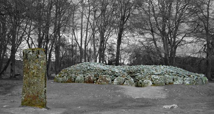 Un mojón de piedra rodeado por un grupo de árboles.