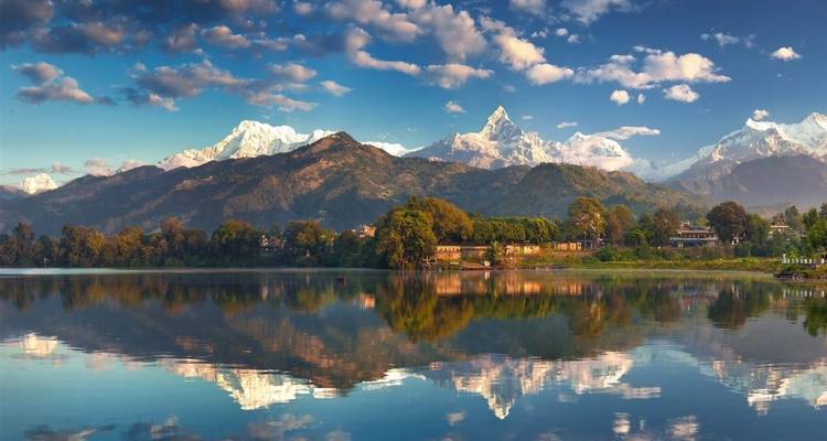 Reflet de montagnes dans un lac calme sous un ciel bleu.