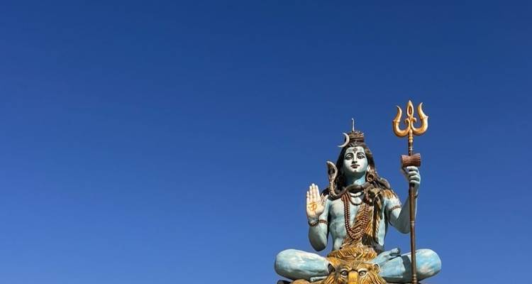 Statue d'une divinité contre un ciel bleu vif.