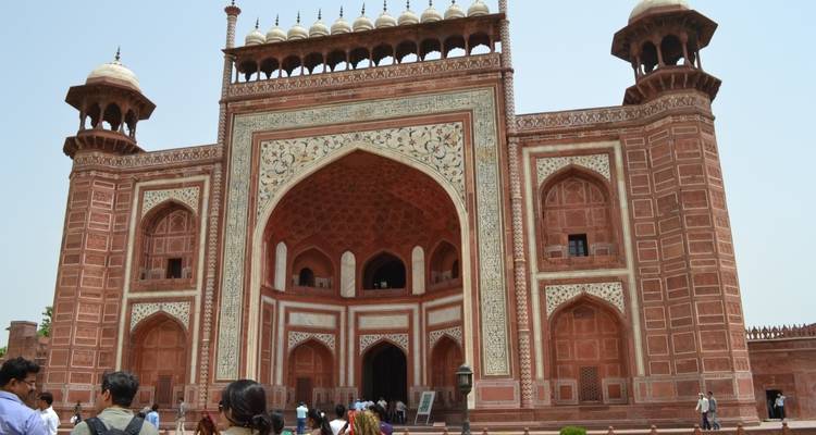 Bezoekers voor de grote toegangspoort van het Taj Mahal-complex.