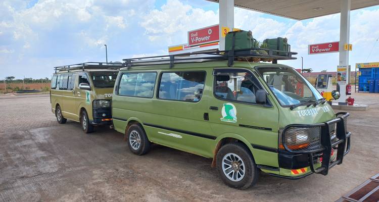 Des fourgonnettes de tournée garées à une station-service.