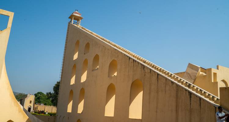 Steile driehoekige zonnewijzer van Jaipur's Jantar Mantar observatorium tegen een heldere blauwe hemel.