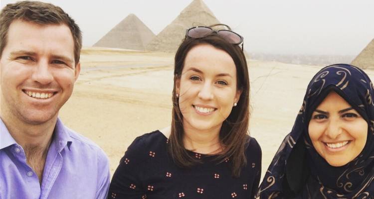 Groepsfoto van mensen met de piramides van Gizeh op de achtergrond.