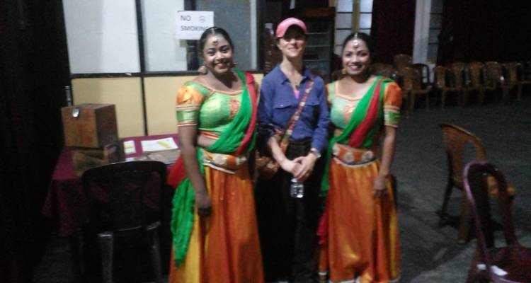 Woman posing with dancers backstage.
