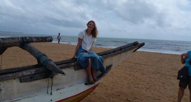 Woman sitting on a boat at the beach.
