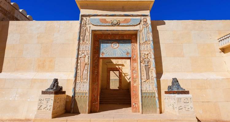 Een oud ogende gebouwingang met gedetailleerde gravures.