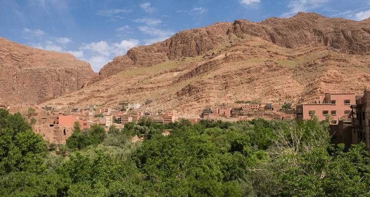 Een bergachtig landschap met een klein dorpje genesteld in het groen.