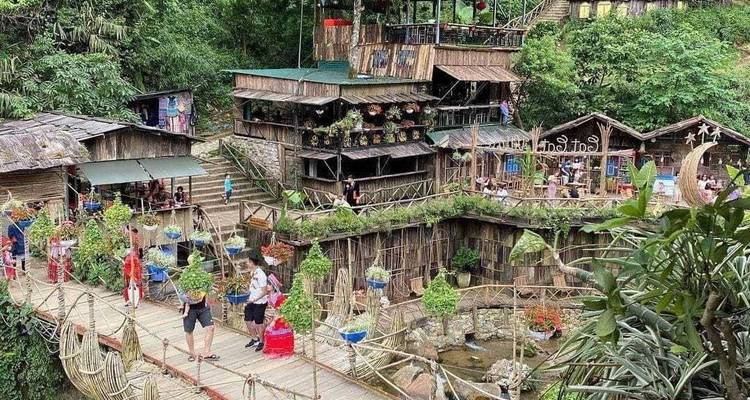 Un village en bois avec un pont suspendu et une végétation luxuriante.