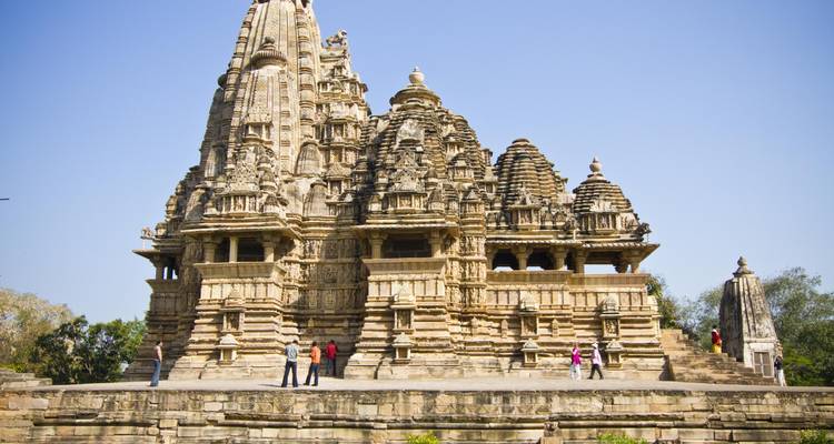 Un grand temple en pierre sculpté de manière complexe avec des gens autour.