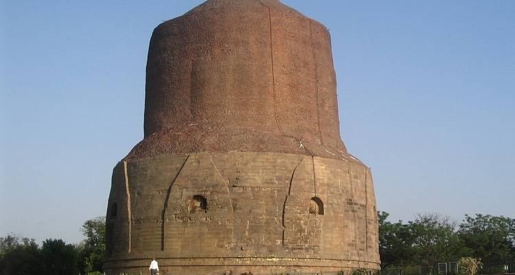 Grande structure de stupa en briques contre un ciel bleu dégagé.