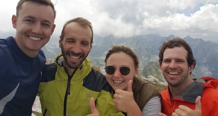 Ein Gruppen-Selfie mit Bergen im Hintergrund aufgenommen.