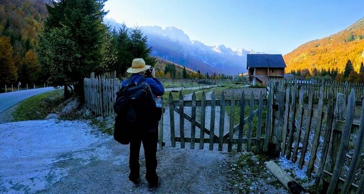 Rucksacktourist steht vor einem Berghaus.