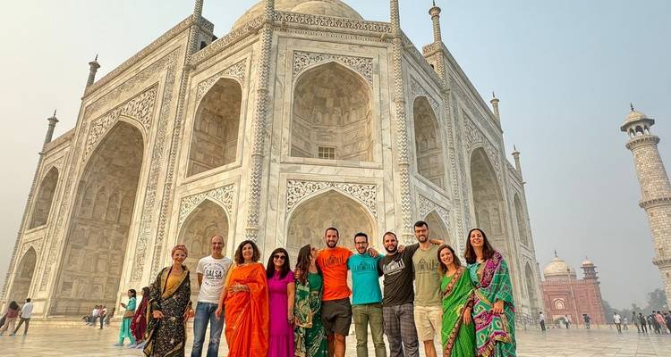 Gruppe von Touristen in traditioneller Kleidung am Taj Mahal.