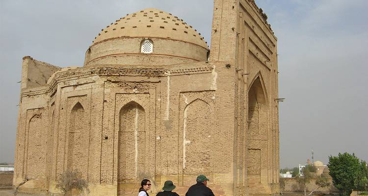 People sitting by an old domed building.