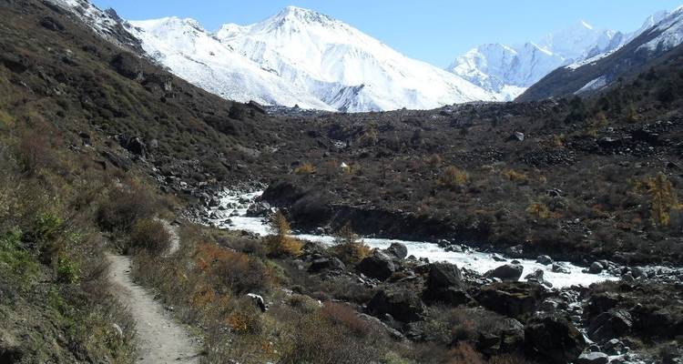 A mountain landscape with a river running through rocky terrain.