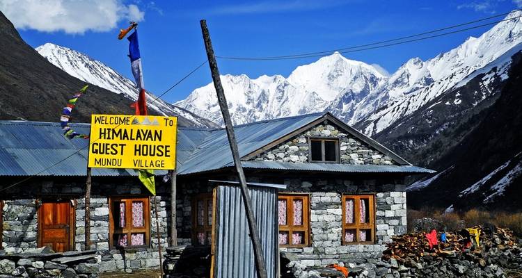 Himalayan guest house with snowy peaks in the distance.
