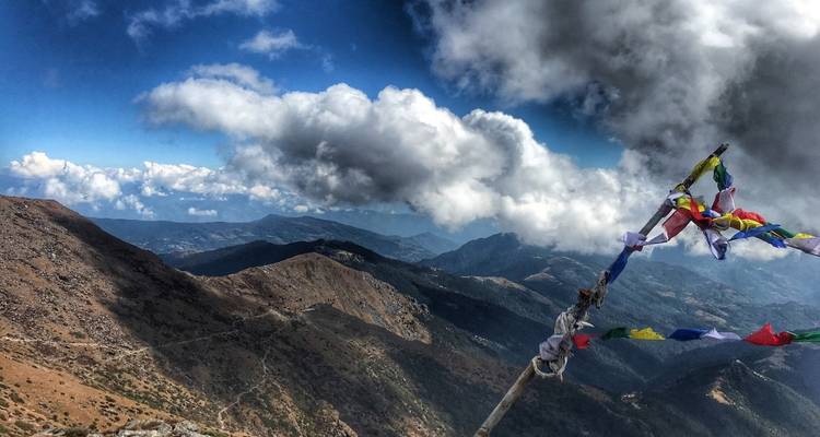 Himalaya-gebergte met gebedsvlaggen onder een bewolkte hemel.