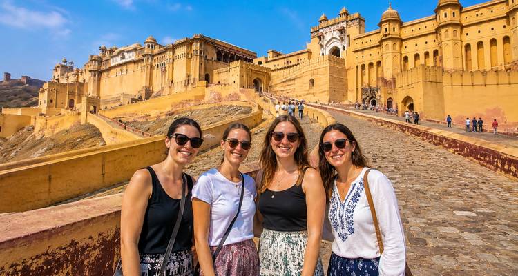 Vrienden staan op de grote geplaveide helling van Amber Fort met zijn gouden zandstenen muren.