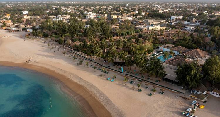 Vue aérienne d'une zone de villégiature en bord de mer avec une végétation luxuriante.