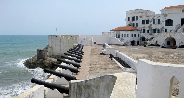 Fuerte costero con cañones apuntando hacia el mar en Elmina.