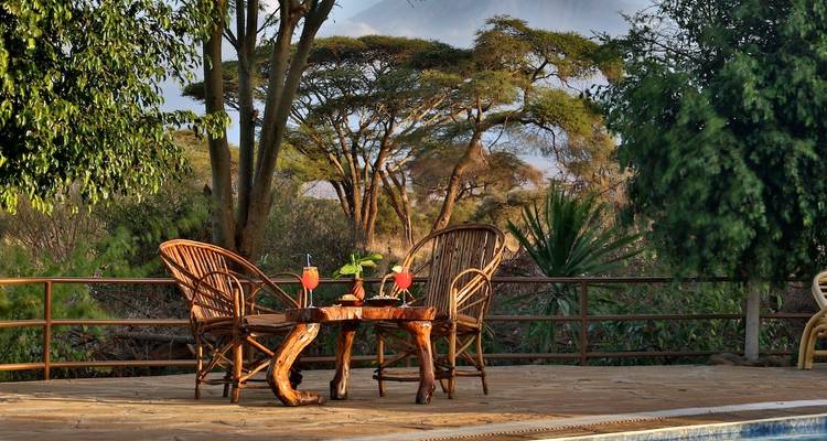 Außensitzbereich mit Getränken, mit Blick auf eine Naturlandschaft.