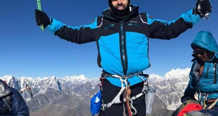 Bergsteiger auf einem verschneiten Gipfel feiern die Besteigung.