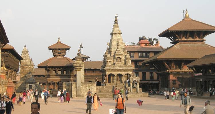 Group of people walking in a historic square with temples.