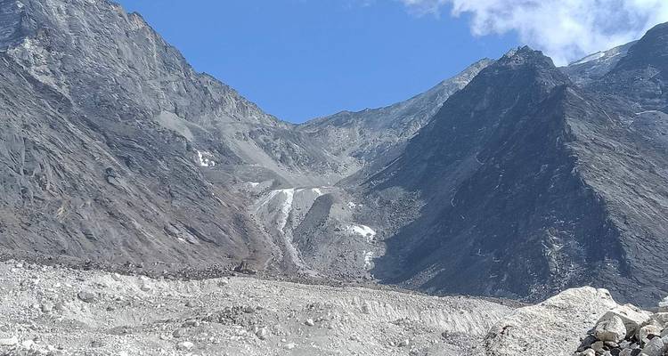 A dry rocky landscape with glacial elements in the background.