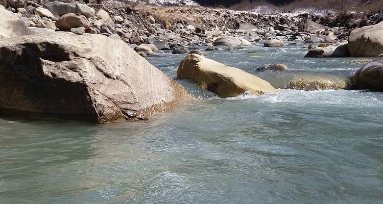 A river with rocks flowing through a mountainous area.