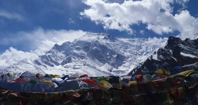 Prayer flags in the foreground against a breathtaking snowy mountain.