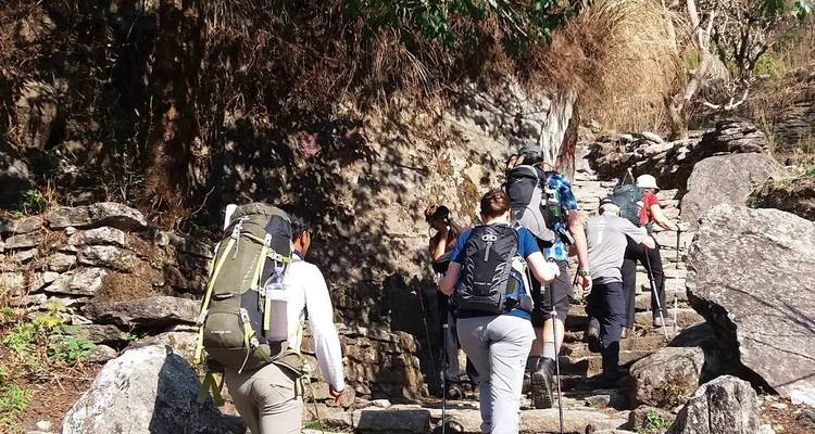 A group of hikers ascending a rocky path in a mountainous area.