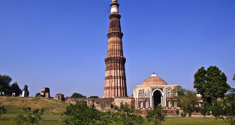 Ein hoher historischer Turm umgeben von Gärten.