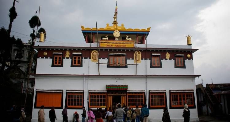 Traditional Buddhist monastery with people outside.