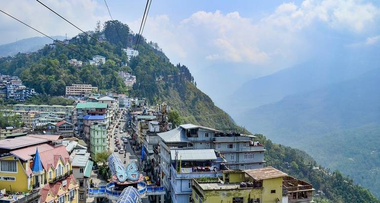 Hill station view with colorful buildings and a scenic mountain backdrop.