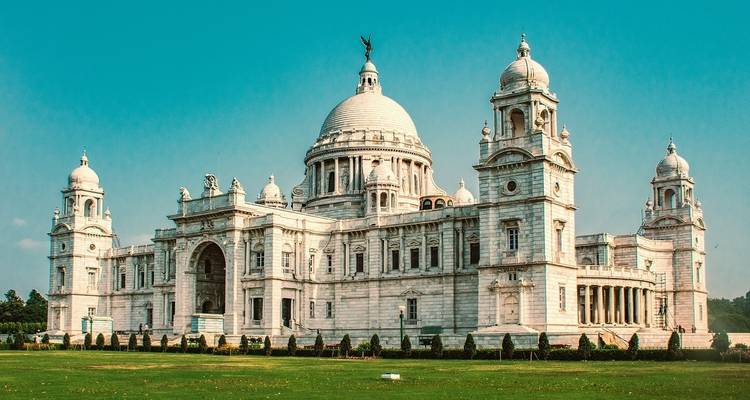 Grand white domed building with manicured lawns.