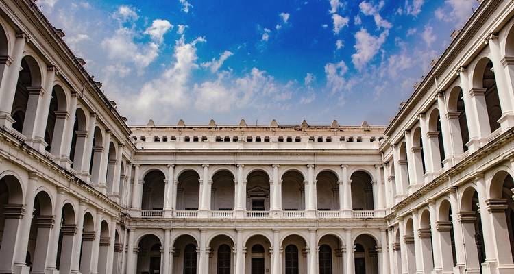 Courtyard with arches and a blue sky.