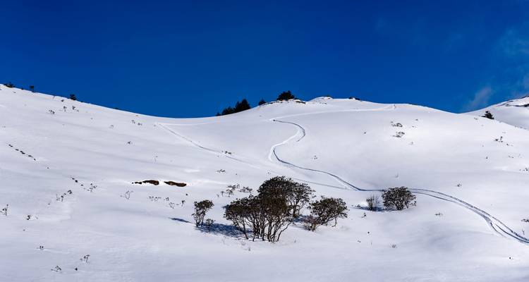 Schneebedeckte Hügel mit einem klaren blauen Himmel.