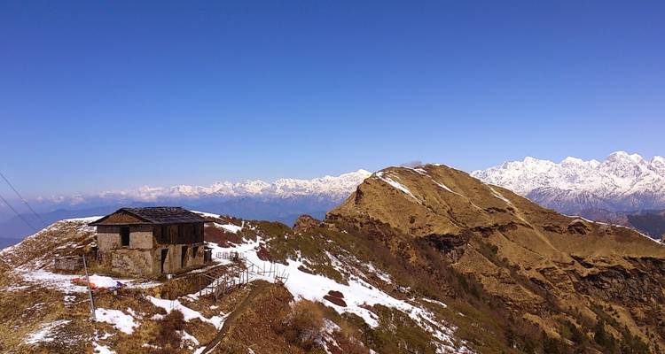 Berglandschaft mit einem kleinen Haus auf einem Grat.