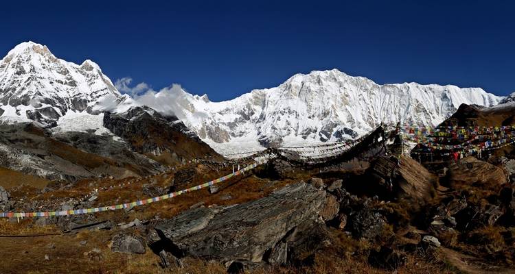 Verschneites Bergpanorama mit Gebetsfahnen.