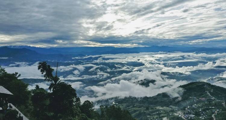 Clouds over a lush green mountainous landscape.