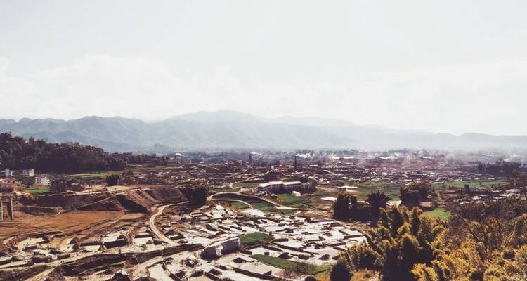 Overlooking a valley with a town and distant hills.
