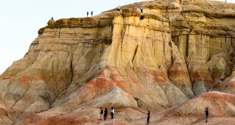 Visitors walking on a colorful cliff formation